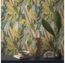 Close-up van een wand met bladerpatroonbehang en decoratieve objecten op een tafel.