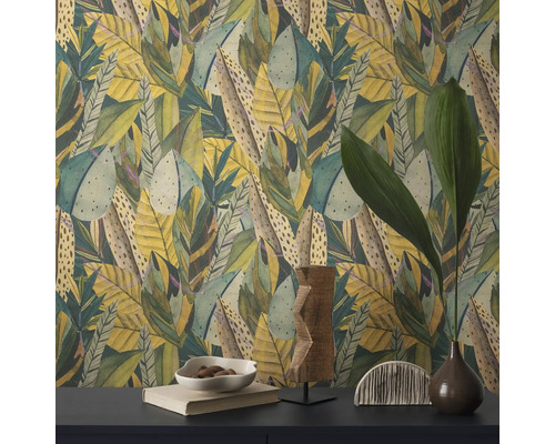 Close-up van een wand met bladerpatroonbehang en decoratieve objecten op een tafel.