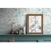 Decoratieve scène met bloemenbehang, ingelijste plantenafbeelding en decoratieve objecten op een plank