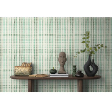 Inrichtingsvoorbeeld met patroonbehang, houten tafel en decoratieve objecten.