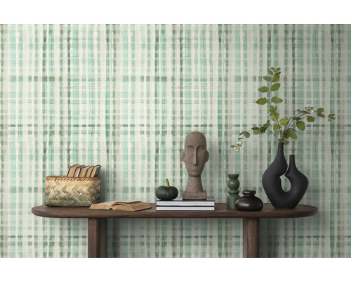 Inrichtingsvoorbeeld met patroonbehang, houten tafel en decoratieve objecten.