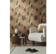 Woonkamer met behang met patroon, fauteuil en decoraties op bijzettafels