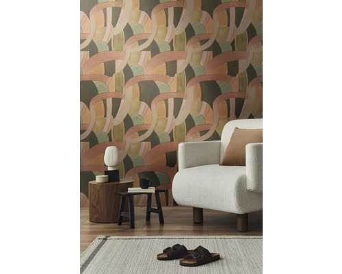 Woonkamer met behang met patroon, fauteuil en decoraties op bijzettafels