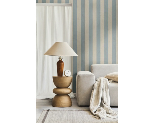 Woonkamer met lamp op bijzettafel, bank, kussens en vloerkleed