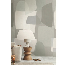 Woonkamer met behang in abstracte vormen, tafellamp, bijzettafel en bank