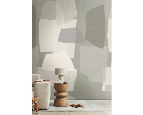 Woonkamer met behang in abstracte vormen, tafellamp, bijzettafel en bank