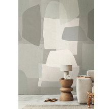 Woonkamer met geometrisch behang, tafellamp en bank