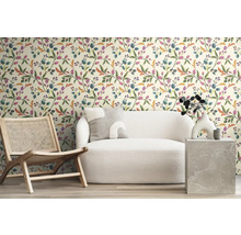 Woonkamer met patroonbehang, fauteuil en bank voor een gezellige sfeer.