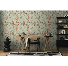 Een werkkamer met een bureau voor een muur met een bloemenbehang.