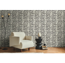 Kamer met fauteuil, bijzettafel en behang met zebrastrepenpatroon