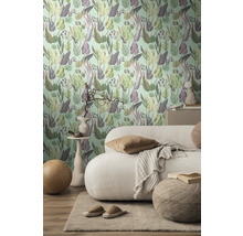 Woonkamer met een muur met botanisch patroonbehang, bank en vloerkleed