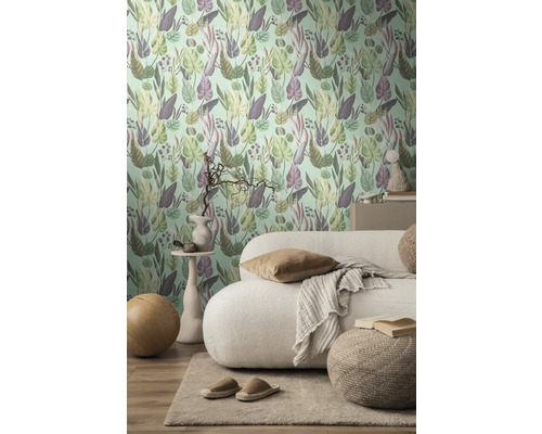 Woonkamer met een muur met botanisch patroonbehang, bank en vloerkleed