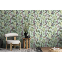 Een kamer met een behang met bladerenmotief, een stoel en een bijzettafel.