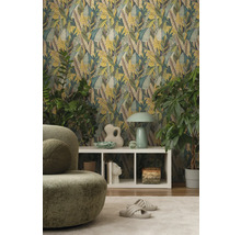 Woonkamer met bladerbehang, groene fauteuil en witte kast