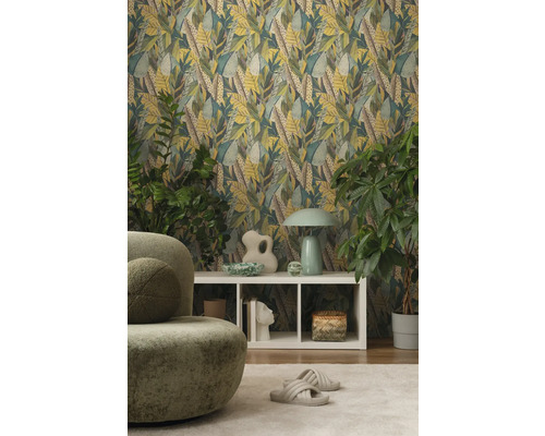 Woonkamer met bladerbehang, groene fauteuil en witte kast