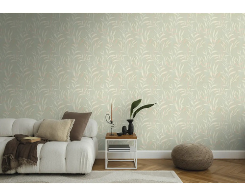Woonkamer met behang met bladmotief, bank, bijzettafel en poef