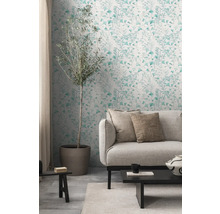 Woonkamer met bank, tafel en wandbehang met plantenmotief