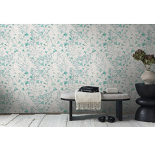 Decoratief interieur met een wandbehang met bladerpatroon, een bank en een bijzettafel met een bloemenvaas