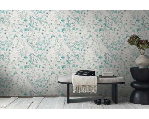 Decoratief interieur met een wandbehang met bladerpatroon, een bank en een bijzettafel met een bloemenvaas