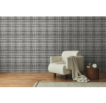 Woonkamer met patroonbehang en fauteuil