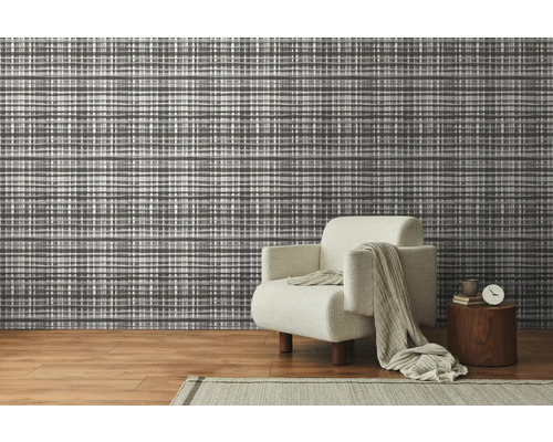 Woonkamer met patroonbehang en fauteuil