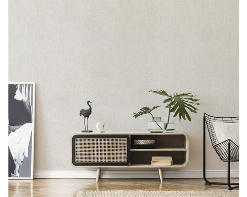 Woonkamer met dressoir, decoraties, plant en fauteuil.