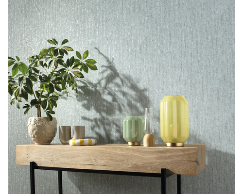 Scene met patroonbehang, plant en decoratieve lampen op een houten tafel