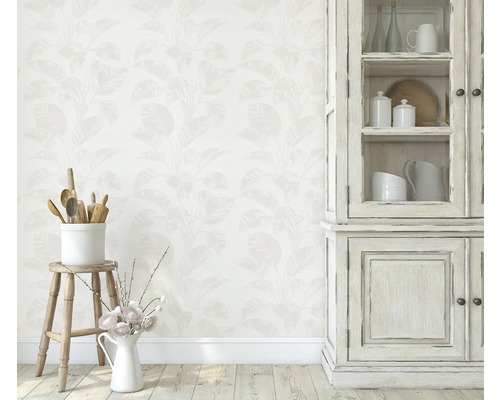 Woonkamer met behang met bloemenmotief, keukengerei en glazen kast