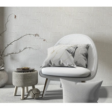 Decoratieve scène met stoel, kussens en behang met patroon voor een heldere en georganiseerde ruimtesfeer.