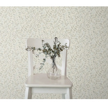 Decoratief behang met bladerpatroon, gecombineerd met een stoel en een vaas met takken voor een stijlvolle kamerambiance.