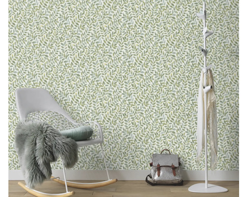 Kamer met een behang met bladmotief, een schommelstoel en een kapstok.