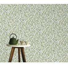 Behang met bladerpatroon op de achtergrond, theepot en kommen op een tafel