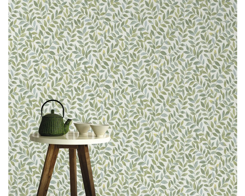 Behang met bladerpatroon op de achtergrond, theepot en kommen op een tafel