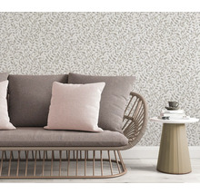 Scene met bank, kussens, bijzettafel en behang met bladmotief