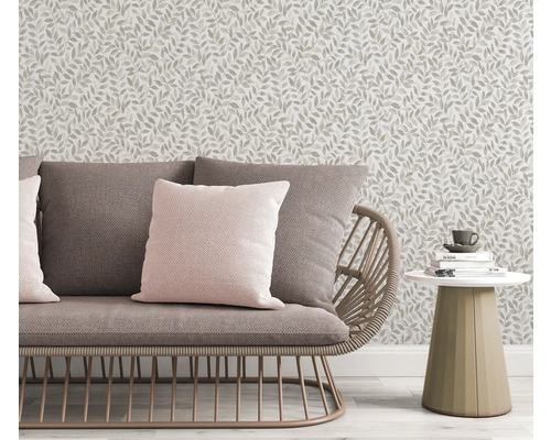 Scene met bank, kussens, bijzettafel en behang met bladmotief