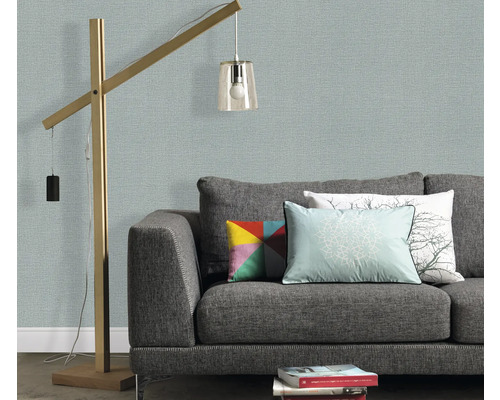 Woonkamer met grijze bank, kussens en staande lamp