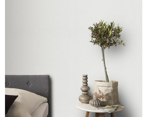 Lichte slaapkamer met bed en nachtkastje met decoratie en plant