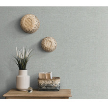 Decoratieve muur met getextureerd behang, twee wandmanden, plantenvaas en opbergmand