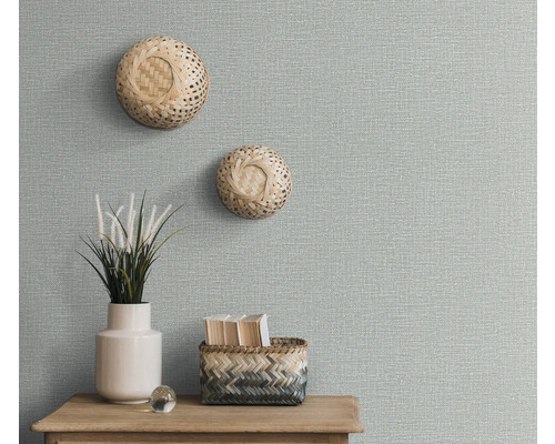 Decoratieve muur met getextureerd behang, twee wandmanden, plantenvaas en opbergmand