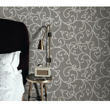 Slaapkamer met patroonbehang, nachtkastje, lamp en radio wekker