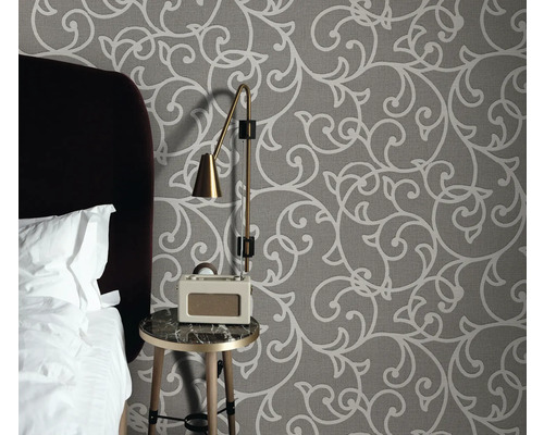 Slaapkamer met patroonbehang, nachtkastje, lamp en radio wekker