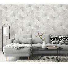 Woonkamer met grijze bank, tafel en bloemenbehang