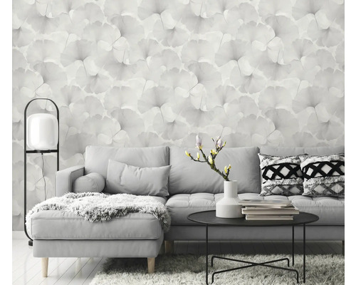 Woonkamer met grijze bank, tafel en bloemenbehang