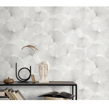 Decoratieve wand met behang met ginkgo-bladeren, boekenplank, vazen en sculpturen