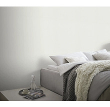 Lichte slaapkamer met bed, dekens en bijzettafel