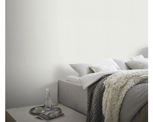 Lichte slaapkamer met bed, dekens en bijzettafel