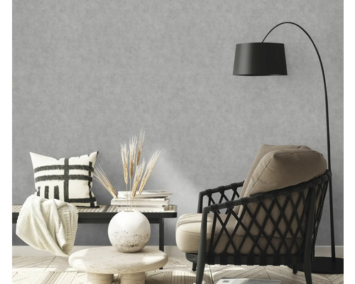 Woonkamer met grijs betonlook behang, fauteuil en vloerlamp