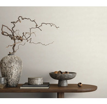 Decoratieve opstelling met vaas, takken, schalen en boeken op een houten tafel