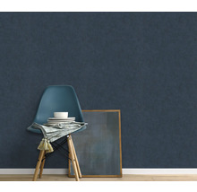 Scène met donkerblauw vliesbehang, stoel, servies, servet en ingelijste afbeelding