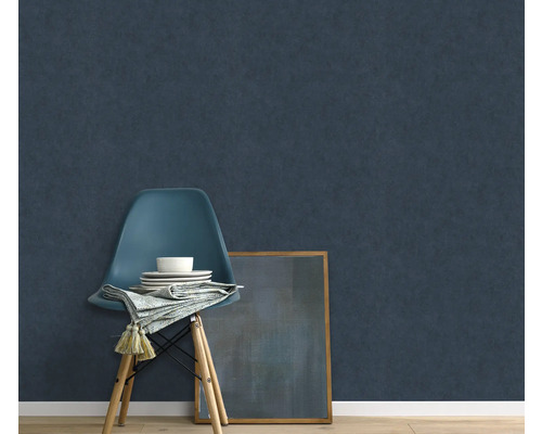 Scène met donkerblauw vliesbehang, stoel, servies, servet en ingelijste afbeelding